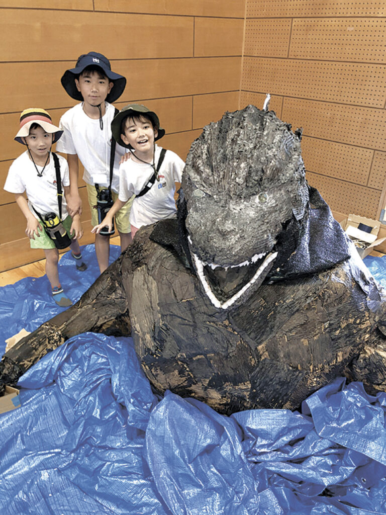 制作が進むゴジラ模型の頭部。段ボール製とは思えない迫力に、子供たちは「すごい」と驚いていた