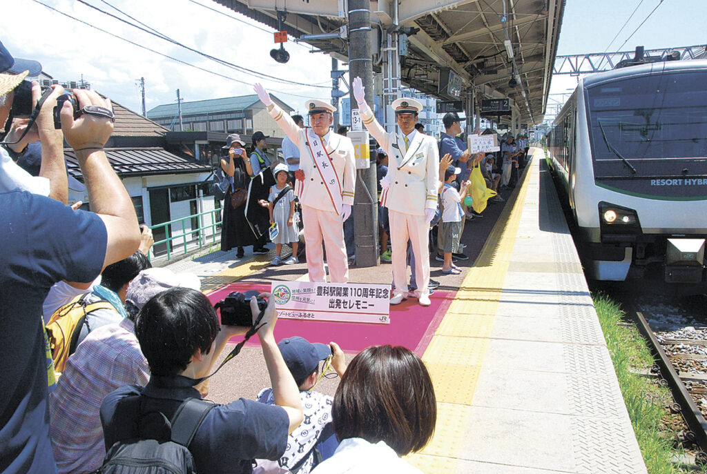 駅開業１１０周年記念の出発セレモニーを記念撮影する人たち