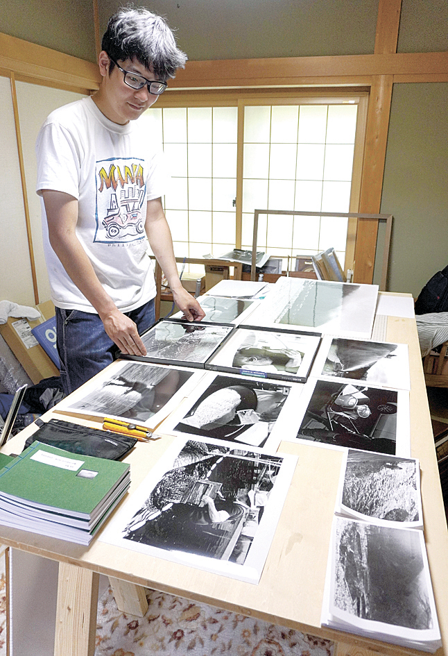 成果発表の個展に並べる写真を準備する高橋さん