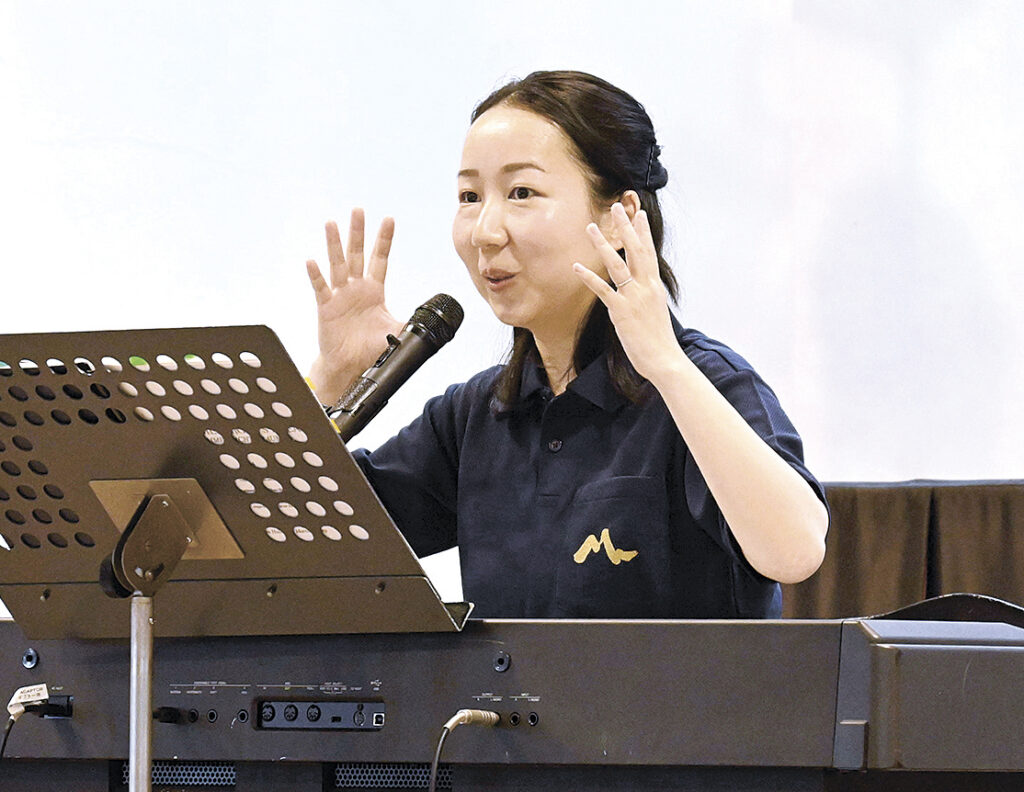 演奏されるメロディーをキーボードで弾きながら紹介する沖澤さん