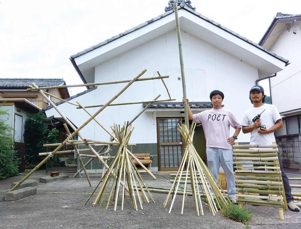 土蔵の前でテントの骨組みと竹灯籠を製作する松尾さん(左)と山崎さん