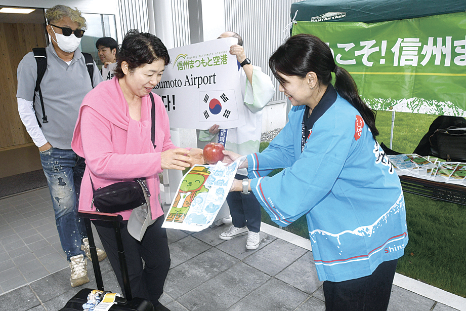 松本産のリンゴを受け取る韓国からの観光客