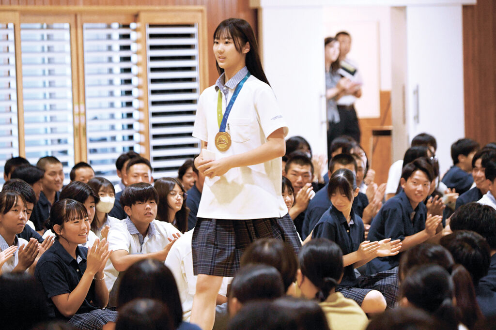 全校生徒の拍手に迎えられながら入場する花村さん