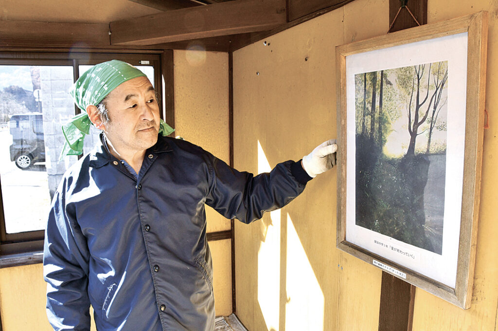 メンバーにより閉校となる開田中学校の生徒の絵が掲げられたバス停