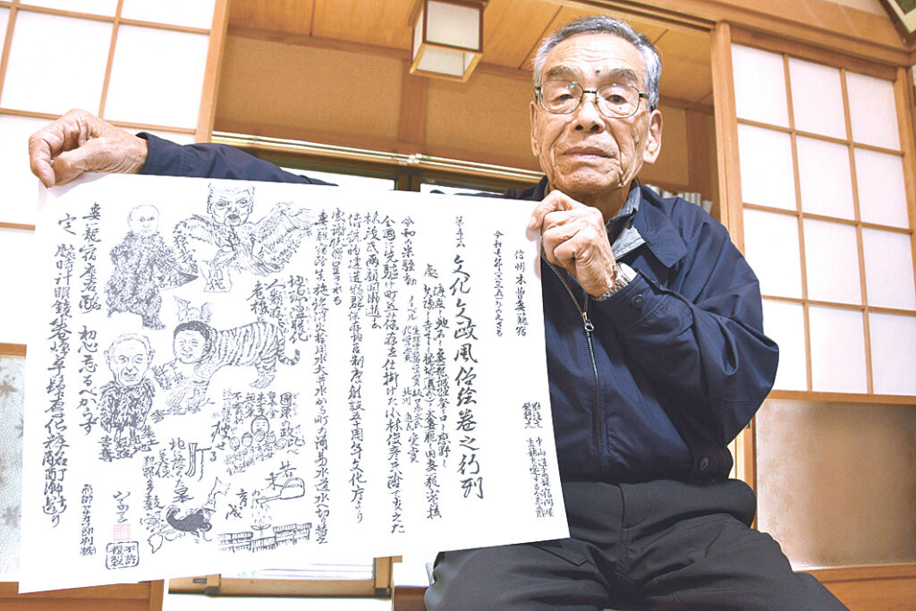 今年の世相を鋭く描く恒例の瓦版と制作者の藤原さん