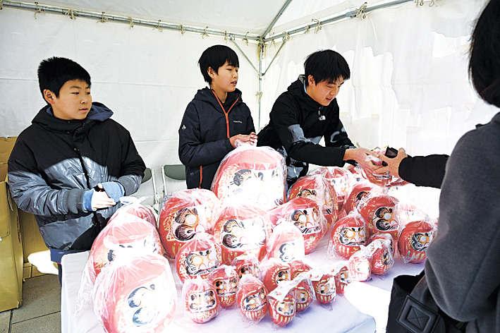 元気いっぱいに福だるまを販売する子供たち（伊勢町通り）