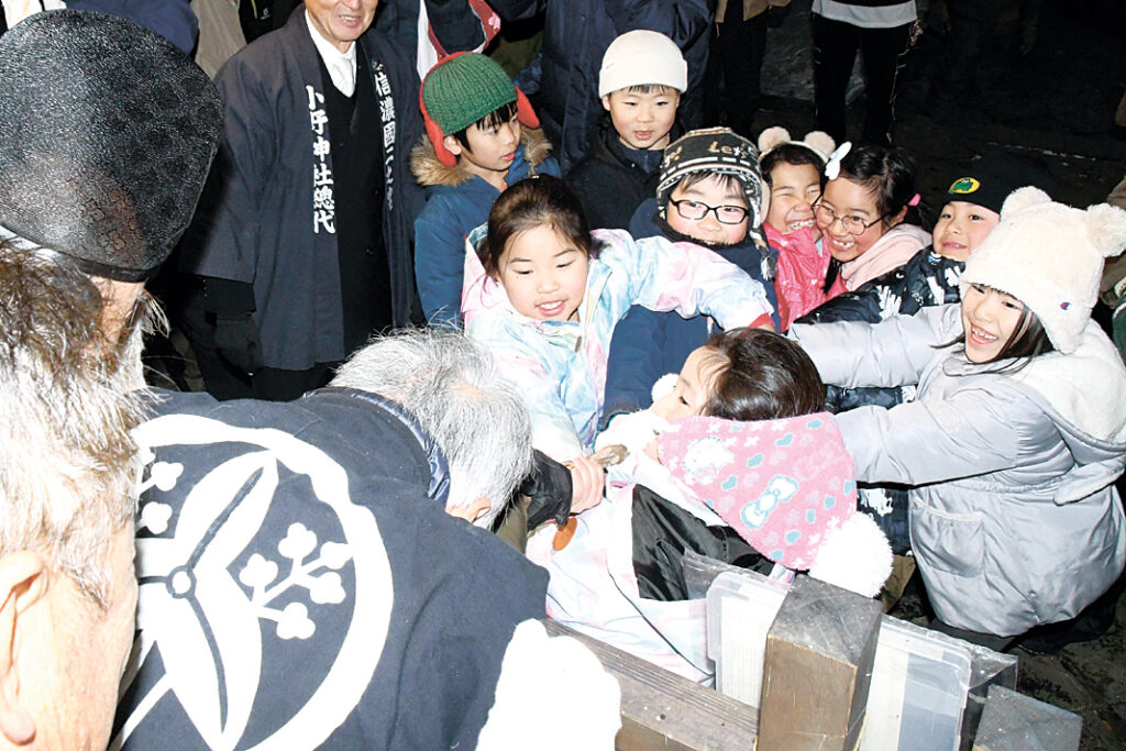 棒を引っ張って力比べをする子供たち