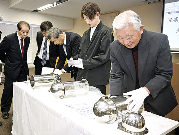 カプセルから手紙を取り出す宮澤会長、齊藤さん、中山市長（右から）